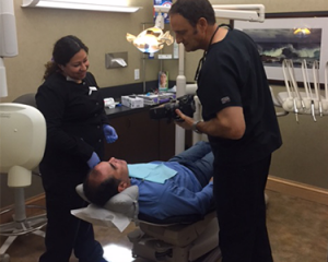 The La Costa Dental Excellence dental team in an exam room during porcelain veneer treatment.